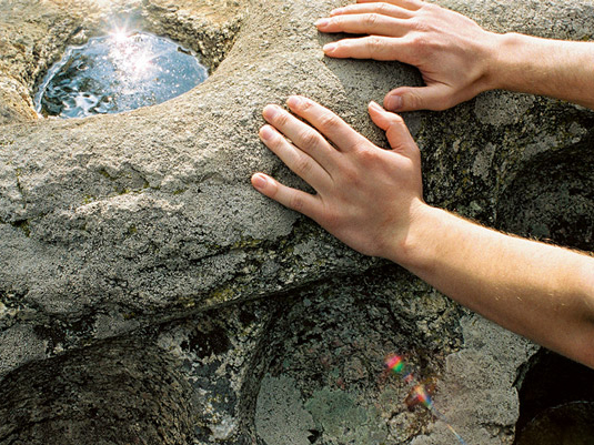 Hände auf dem Heiligen Stein